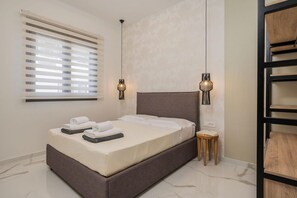 Ein modernes Schlafzimmer mit einem großen Bett, zwei Nachttischen, einem Fenster mit Jalousien und einer eingebauten Regaleinheit.