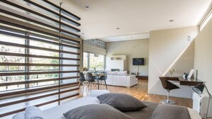 A modern bedroom with a large bed, a desk, and a TV. - Studio Rio: Unique space with garden and garage (Ρίο)