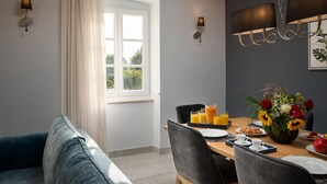 Un comedor con una mesa dispuesta para el desayuno, con zumo de naranja y bollería.