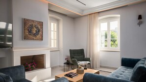 Una sala de estar moderna con chimenea, dos sofás, una mesa de centro y un televisor.