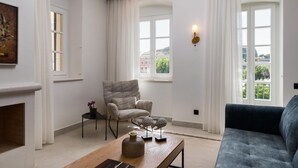 Un salon moderne avec une cheminée, un canapé, un fauteuil et une table agrémentée d’objets décoratifs.