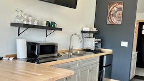 Une cuisine moderne dotée d’un plan de travail en bois, d’appareils électroménagers en acier inoxydable et d’un évier encastré.