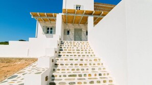 Un edificio blanco con una escalera que lleva a un vestíbulo cubierto.
