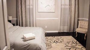 Una habitación de hotel con una cama, una silla, un tapete decorativo y un cuadro en la pared.