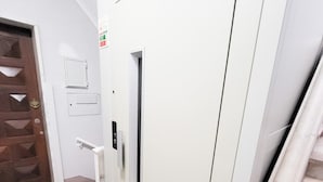 A modern elevator with a marble floor and a wooden door. - T2-MAMA II.  AC FRENTE MAR (Quarteira)