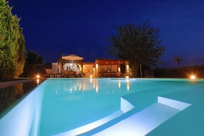 A swimming pool with a sunken seating area, a covered outdoor area with tables and chairs, and a basketball hoop. - Villa Teresa in Roda (Roda)