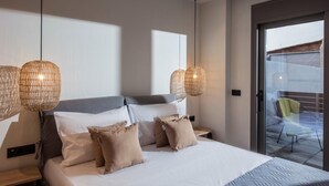 A modern hotel room with a large bed, two bedside tables, and a balcony with a chair. - Festos Palace by Luxury Living Apartments (Gournes)