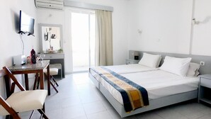 A hotel room with a bed, a desk with a chair, a television, and a window with curtains. - Lefteris Insta-worthy Studio with Balcony (Ialisos)