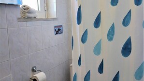 A bathroom with a sink, toilet, and shower curtain with a blue leaf pattern. - Lefteris Insta-worthy Studio with Garden View (Ialisos)
