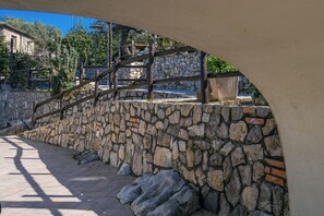 A stone wall with a wooden staircase leading to a higher level. - The Ancient Pine Cone Chateau - Light Blue (Vico Equense, Campania)