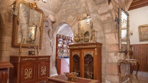 A room with stone walls, wooden furniture, and ornate mirrors. - Megiston House in Old Town Rhodes (Rodos)