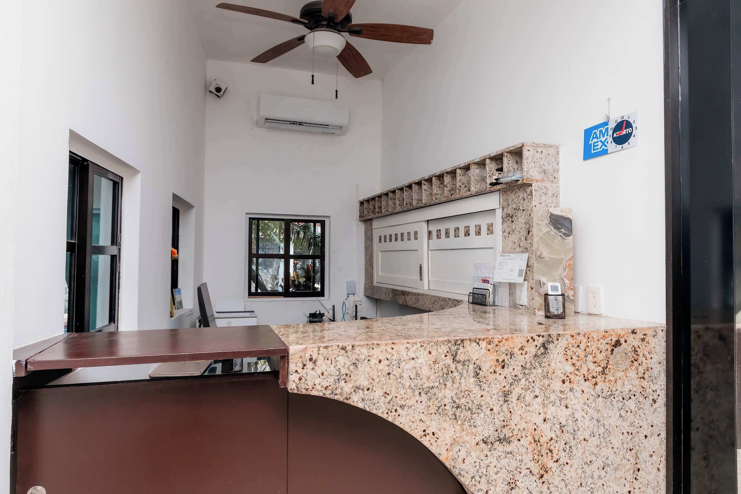 A modern kitchen with granite countertops, a ceiling fan, and a window with a view.
