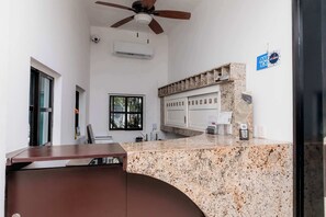 Eine moderne Küche mit Granit-Arbeitsplatten, Deckenventilator und Fenster mit Blick.