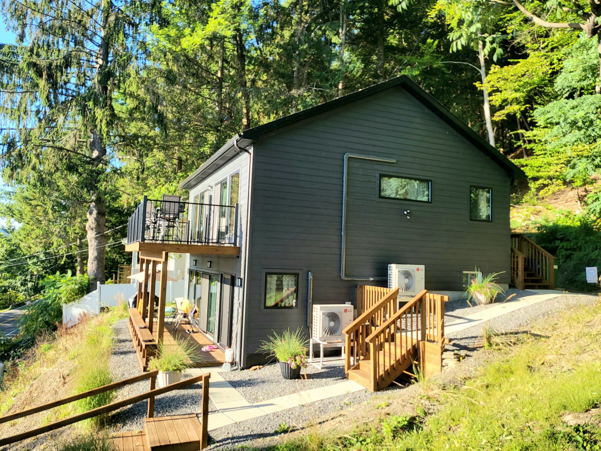 A modern two-story house with a balcony, a staircase, and a front porch.