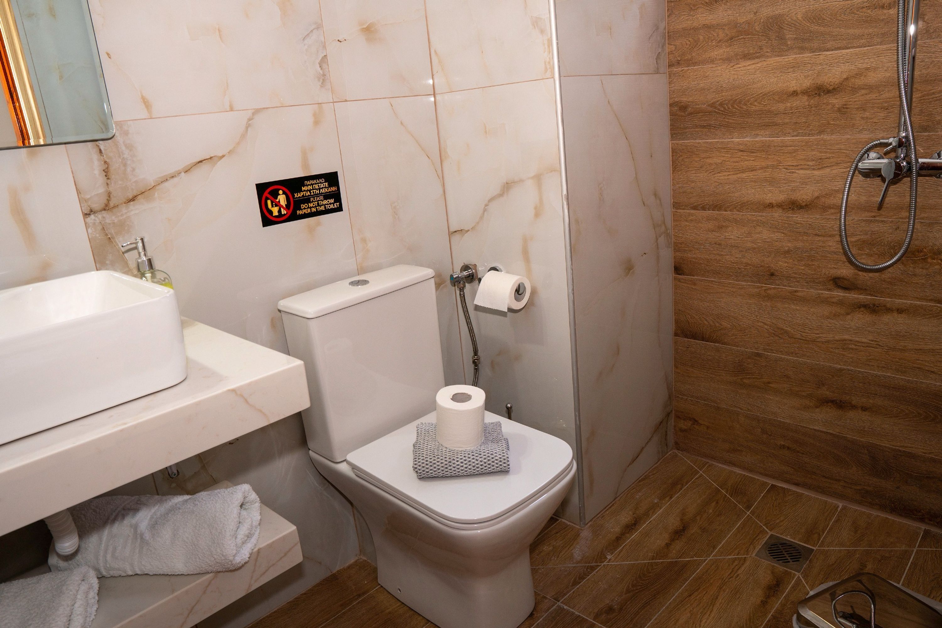 Un bagno con il water, lavandino e doccia.