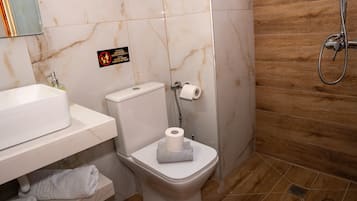 Un bagno con il water, lavandino e doccia.