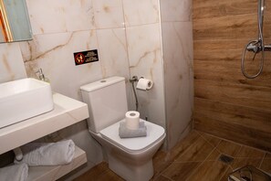 Un bagno con il water, lavandino e doccia.