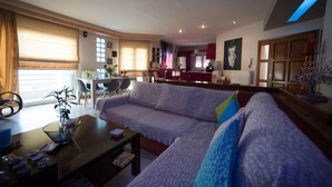 Ein Wohnzimmer mit Sofa, Couchtisch und Essbereich mit Stühlen.