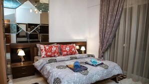 A bedroom with a bed, nightstands, a mirror, and curtains. - Vosinakis House in Volos (Volos)