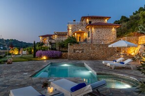 A stone villa with a swimming pool and lounge chairs. - Rodon Luxury Villas "Aria" (Skopelos)