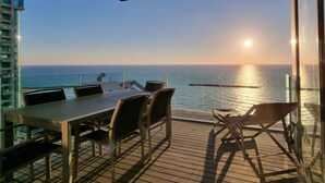A deck with a table and chairs overlooking the ocean. - Hayarkon Blue Sea I in Tel Aviv-Yafo (Tel Aviv-Yafo)