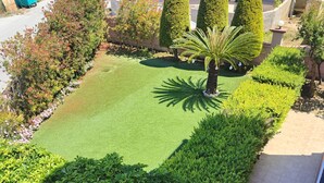 A well-maintained garden with neatly trimmed hedges, a palm tree, and a variety of shrubs. - Aithrea's Homes in Pastida Rhodes (Pastida)