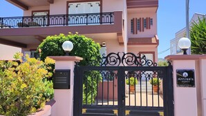 A two-story house with a gated entrance, a balcony, and a small garden area. - Aithrea's Homes in Pastida Rhodes (Pastida)