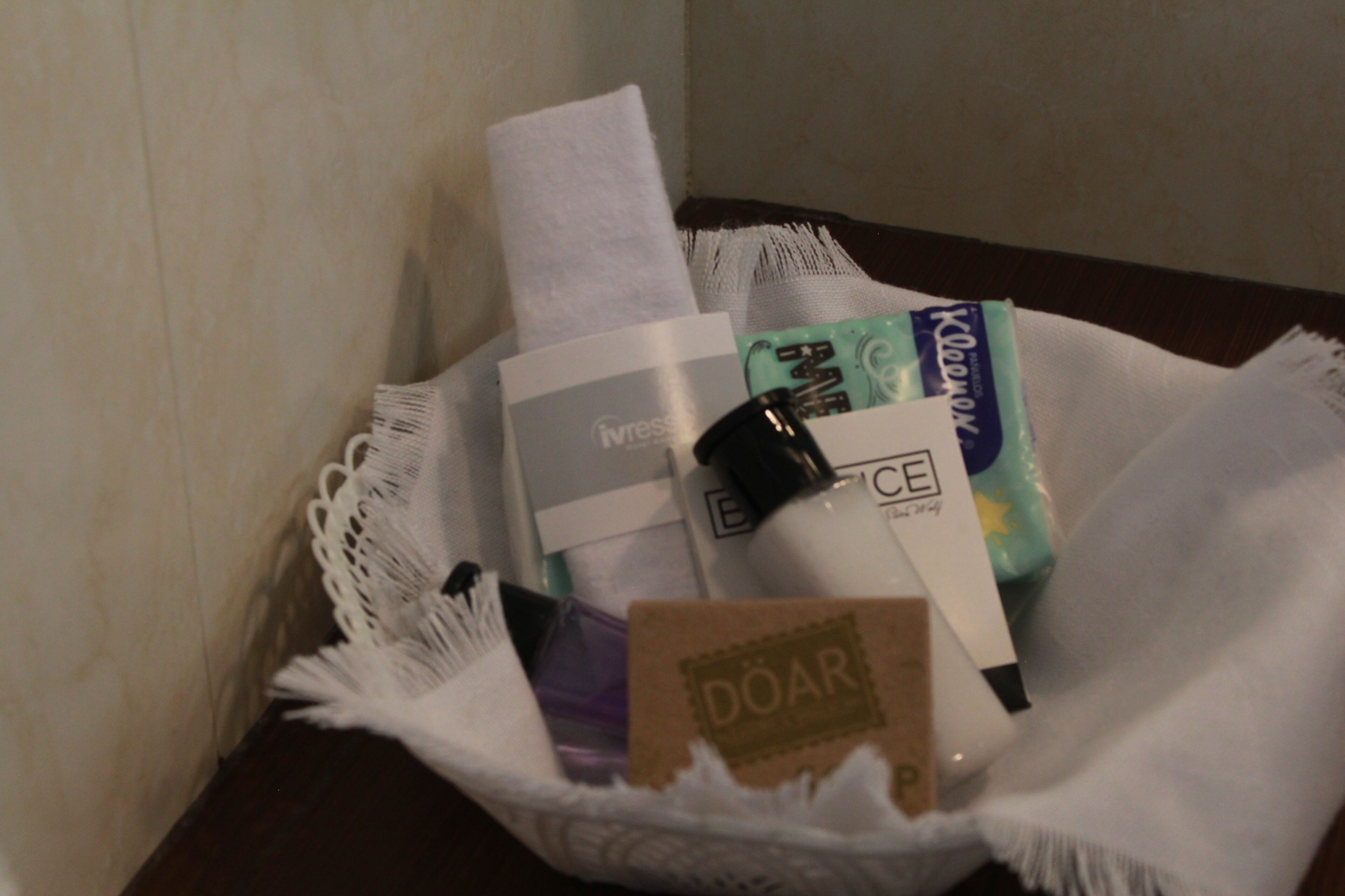 Un panier contenant divers articles de toilette, notamment une brosse à dents, du dentifrice et un savon.