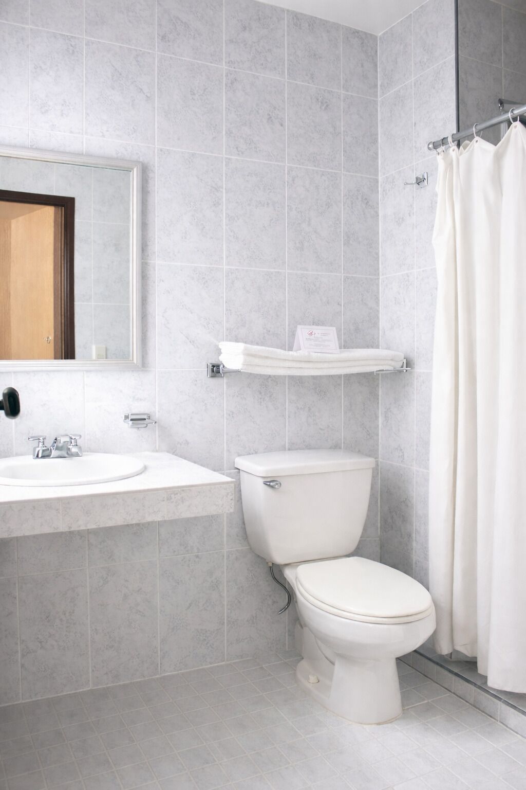A modern bathroom with a toilet, sink, and shower curtain.