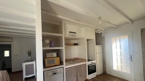 Uma cozinha compacta com lava-louças, micro-ondas, forno e um frigorífico pequeno.