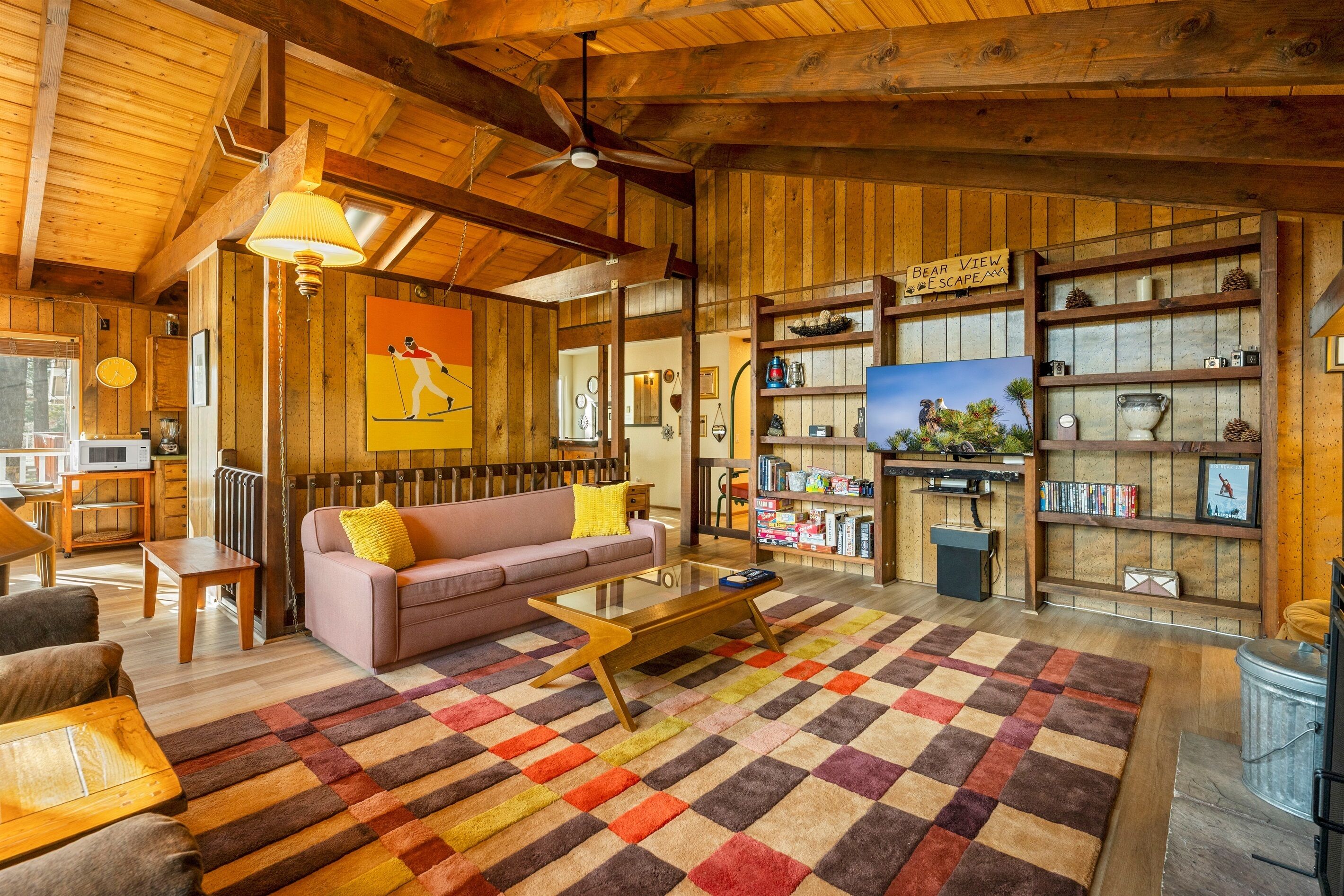 A cozy wooden interior with a sofa, coffee table, and bookshelves.