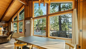Un interior de madera con ventanas amplias, una mesa de comedor y sillas.
