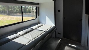 Een modern interieur met een zitgedeelte met een bank, een groot raam en een deur.