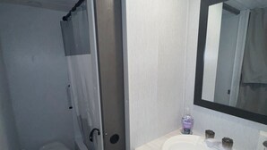Een badkamer met toilet, wastafel en spiegel.