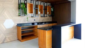 Una cucina moderna con un piano di lavoro in legno, scaffali a incasso e soffitto in legno.