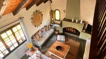 A cozy living room with a sofa, coffee table, and fireplace.