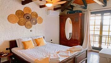 A bedroom with a wooden bed, a ceiling fan, a large mirror, and a wall-mounted woven decoration.