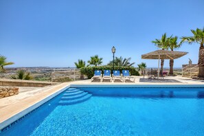 Ein Schwimmbecken mit Liegestühlen und Blick auf die Landschaft.