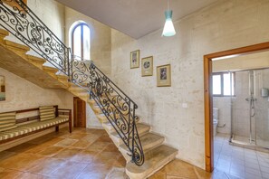 Una scala con ringhiere in metallo decorate, una panchina e un angolo doccia.