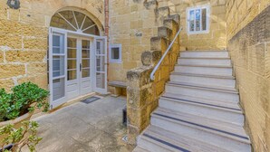 A stone building with a staircase leading to an upper level. - Girardu - Victoria Holiday Home (Victoria)