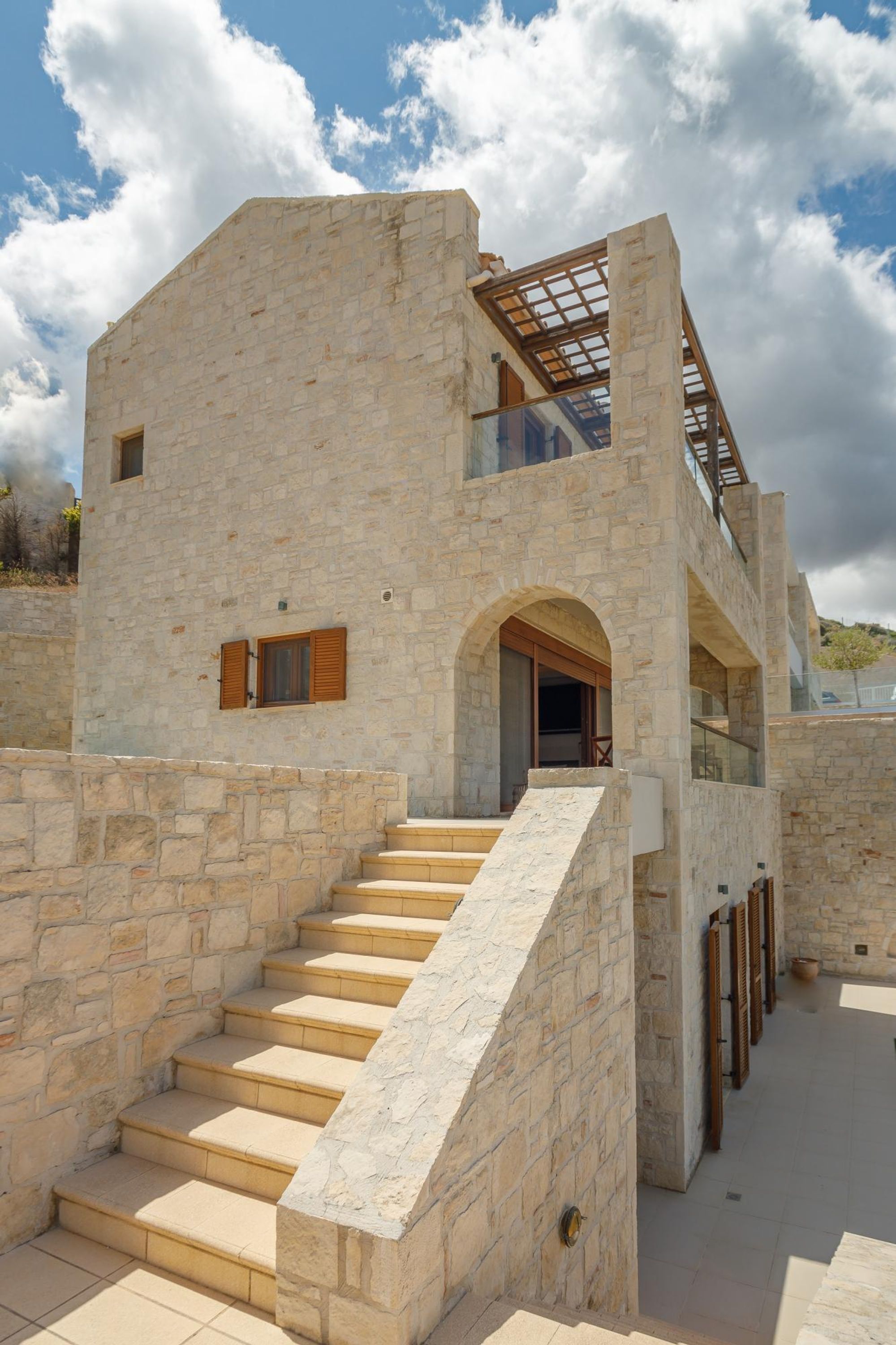 A stone building with a staircase leading to a balcony.