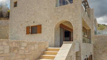 A stone building with a staircase leading to a balcony.