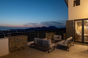 A rooftop terrace with stone walls, a stone fireplace, and outdoor seating. - Villa Sapientza by Modone Villas in Peloponnese (Methoni)