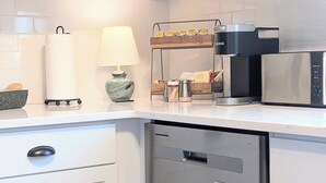 A modern kitchen with a coffee machine, a kettle, and a tea kettle on the counter.