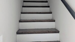 A staircase with alternating dark and light steps, leading to a door at the top.