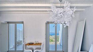 Et moderne hotelværelse med balkon, spiseplads og seng.