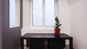 A room with a dark wooden table, a red potted plant, and a window with frosted glass. - Exclusive New Modern Apartment at Syntagma Square (Athina)