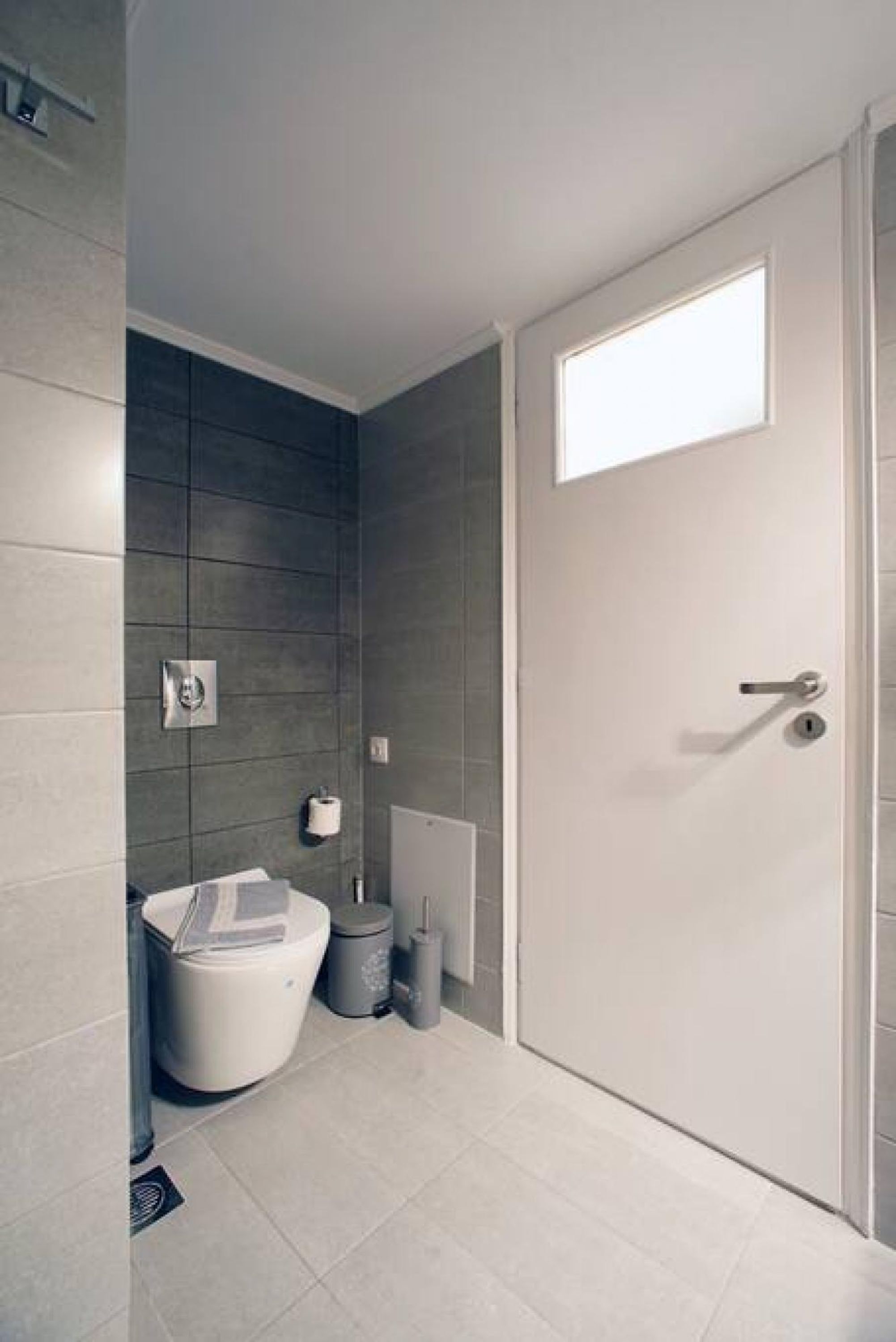 Une salle de bain moderne équipée de toilettes, d’un bidet et d’un porte-serviettes.