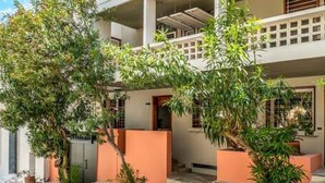 Un edificio de dos plantas con techo plano y un balcón en el piso superior.