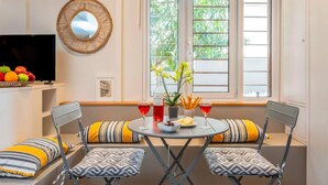 Un rincón acogedor con dos sillones, una mesita, televisor, espejo y ventana con vistas a la vegetación.